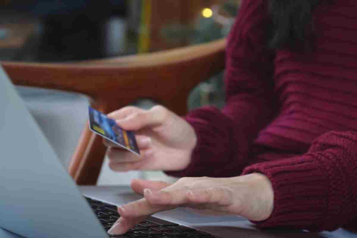 donna controlla dati sulla carta e scrive al pc