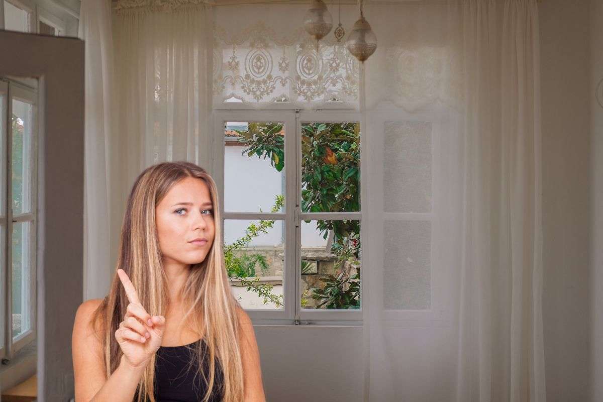 le classiche tende alle finestre ed una ragazza che fa no con la mano