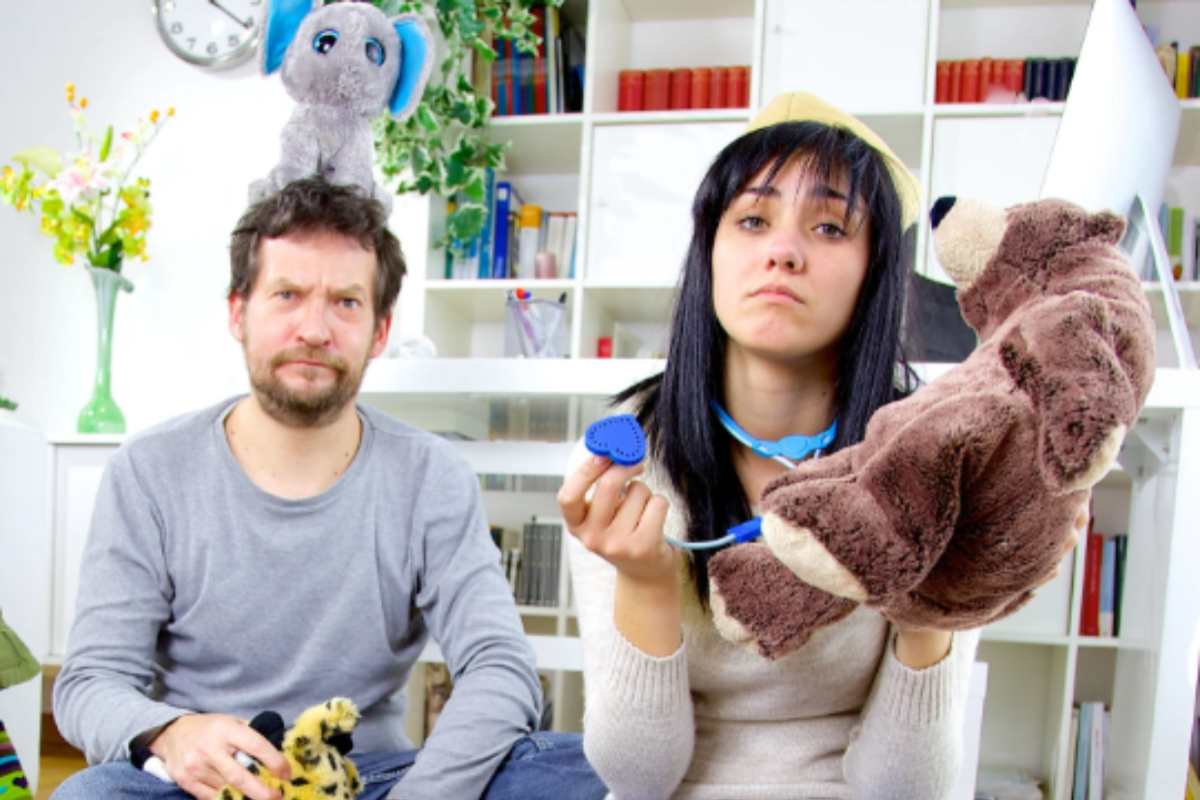 genitori disperati che raccolgono i giochi dei figli sul pavimento