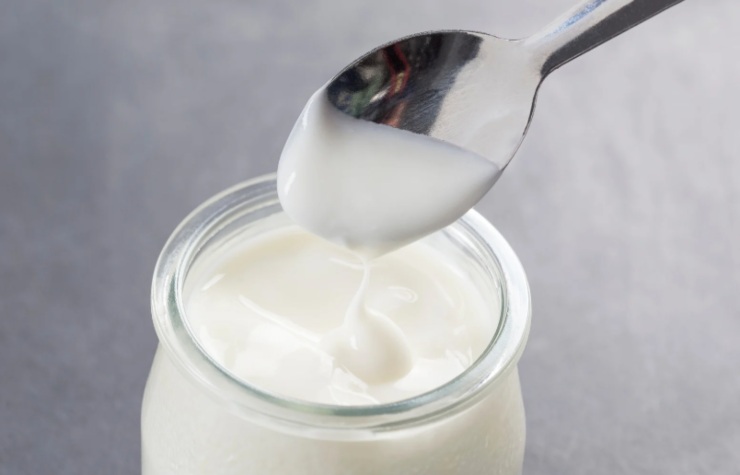 cucchiaino e vasetto di yogurt bianco