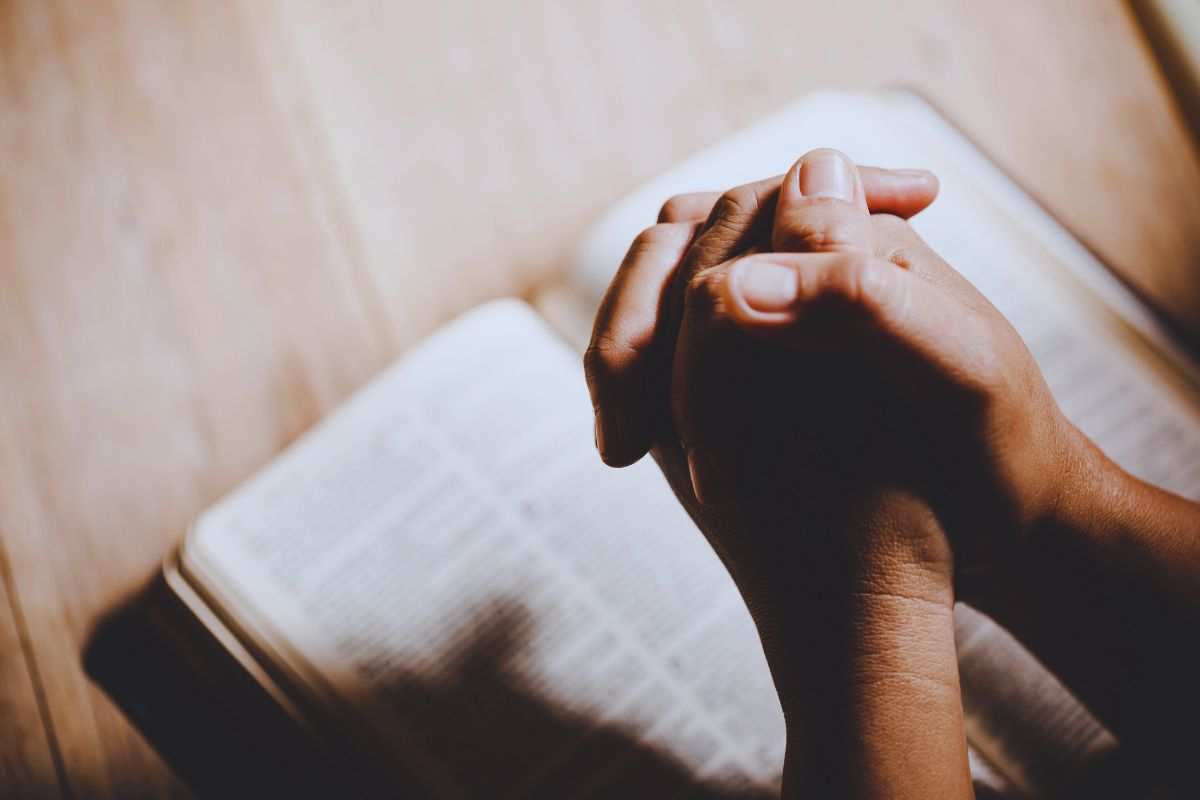 mani giunte su bibbia